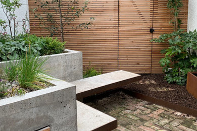 This is an example of a small industrial backyard partial sun garden in Edinburgh with with raised garden bed.