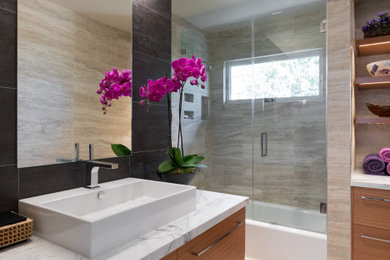 Example of a trendy beige tile beige floor and single-sink bathroom design in San Francisco with flat-panel cabinets, medium tone wood cabinets, a vessel sink, marble countertops, white countertops and a floating vanity