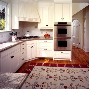 Small traditional kitchen pantry designs - Example of a small classic u-shaped light wood floor kitchen pantry design in Portland with white cabinets, granite countertops, white backsplash, ceramic backsplash, stainless steel appliances, no island, an undermount sink and recessed-panel cabinets