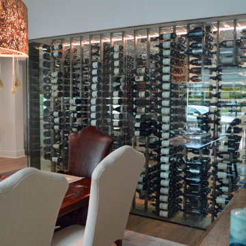 Glass-Enclosed Wine Cellar Matches the Elegant Dining Room in a home in Manhatta