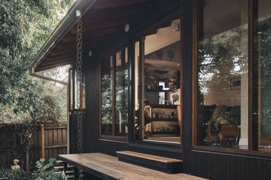 Design ideas for an asian one-storey black exterior in Melbourne with wood siding.
