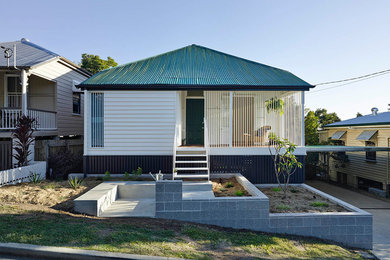 Tropical two-storey white exterior in Brisbane with wood siding.