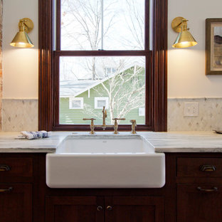Expansive victorian galley kitchen pantry in St Louis with a farmhouse sink, flat-panel cabinets, dark wood cabinets, marble benchtops, white splashback, marble splashback, panelled appliances, medium hardwood floors, with island and white benchtop.