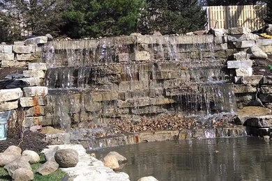 This is an example of a large traditional full sun backyard stone pond in Omaha for fall.