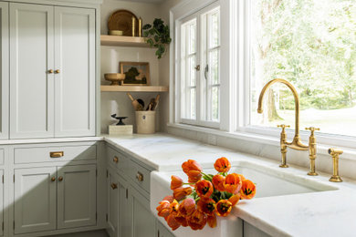Large transitional u-shaped porcelain tile and beige floor enclosed kitchen photo in New York with a farmhouse sink, recessed-panel cabinets, blue cabinets, marble countertops, white backsplash, subway tile backsplash, paneled appliances, an island and white countertops