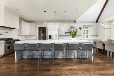 Example of a large transitional l-shaped dark wood floor, brown floor and vaulted ceiling eat-in kitchen design with a double-bowl sink, beaded inset cabinets, beige cabinets, quartz countertops, multicolored backsplash, quartz backsplash, stainless steel appliances, an island and multicolored countertops