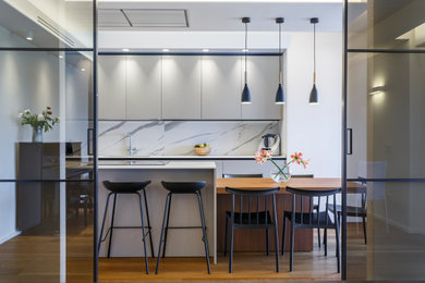 Immagine di una grande e bianca e tortora cucina minimal chiusa con lavello da incasso, ante lisce, ante beige, top in quarzo composito, paraspruzzi bianco, paraspruzzi in quarzo composito, elettrodomestici in acciaio inossidabile, parquet scuro e top bianco