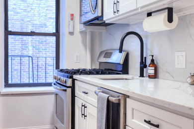 Inspiration for a small transitional galley ceramic tile and red floor enclosed kitchen remodel in New York with an undermount sink, shaker cabinets, white cabinets, quartz countertops, white backsplash, glass sheet backsplash, stainless steel appliances and white countertops