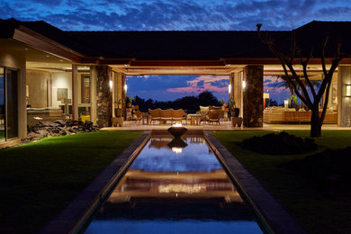 Example of a large island style beige one-story stucco exterior home design in Hawaii with a hip roof