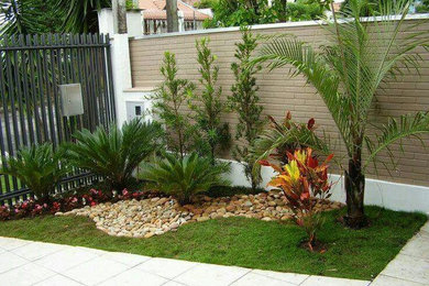 Immagine di un piccolo giardino formale tropicale esposto in pieno sole davanti casa in primavera con pavimentazioni in pietra naturale