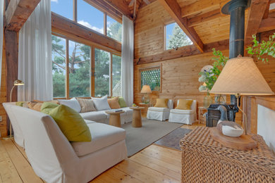 Inspiration for a mid-sized coastal open concept exposed beam and wood wall living room remodel in Portland Maine with a wood stove and a metal fireplace
