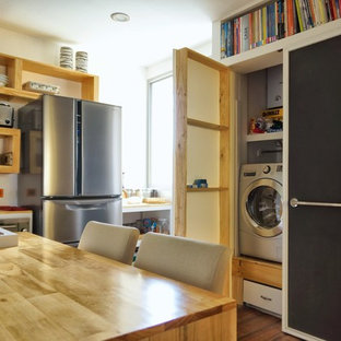 他の地域の小さいトロピカルスタイルのおしゃれなランドリークローゼット (ドロップインシンク、レイズドパネル扉のキャビネット、淡色木目調キャビネット、木材カウンター、白い壁、無垢フローリング、目隠し付き洗濯機・乾燥機) の写真