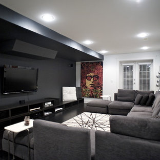 Inspiration for a contemporary home cinema in Vancouver with black walls, a wall mounted tv and black floors.