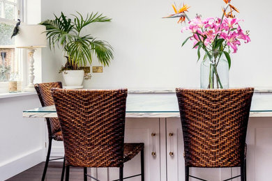 Inspiration for a medium sized contemporary single-wall open plan kitchen in Sussex with an integrated sink, recessed-panel cabinets, white cabinets, marble worktops, black appliances, dark hardwood flooring, an island, brown floors and multicoloured worktops.