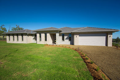 This is an example of a large contemporary one-storey brick house exterior in Other with a tile roof.