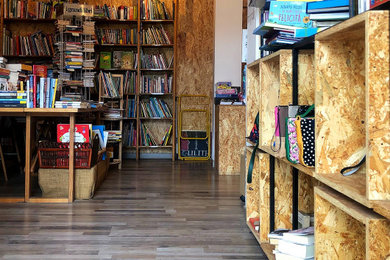 Foto di un piccolo studio industriale con libreria, pareti beige, pavimento in compensato, nessun camino, scrivania incassata, pavimento beige e pareti in legno