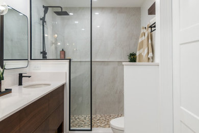 Mid-sized 1960s master multicolored tile and porcelain tile porcelain tile, beige floor and double-sink bathroom photo in Calgary with flat-panel cabinets, medium tone wood cabinets, a one-piece toilet, white walls, an undermount sink, quartz countertops, white countertops and a built-in vanity