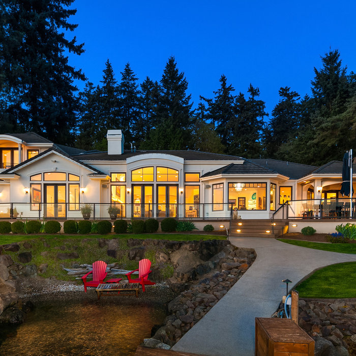 Huge contemporary white two-story stucco house exterior idea in Seattle with a hip roof and a tile roof