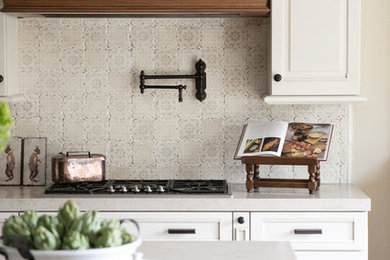 Example of a mid-sized classic single-wall dark wood floor and brown floor open concept kitchen design in San Francisco with white cabinets, beige backsplash, an undermount sink, raised-panel cabinets, quartzite countertops, ceramic backsplash, stainless steel appliances and an island