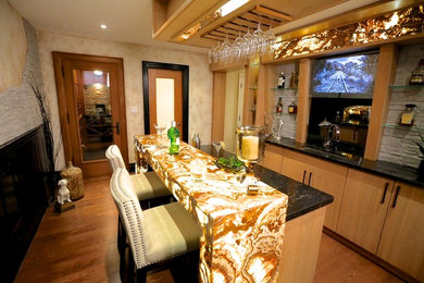 Mid-sized trendy galley light wood floor seated home bar photo in Toronto with an undermount sink, flat-panel cabinets, light wood cabinets, marble countertops, black backsplash and stone slab backsplash