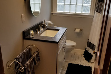 Small elegant master white tile and subway tile marble floor and white floor bathroom photo in Columbus with furniture-like cabinets, white cabinets, a two-piece toilet, gray walls, a drop-in sink, quartz countertops and black countertops