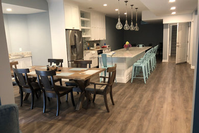 Huge beach style walk-out vinyl floor and brown floor basement photo in New York with blue walls
