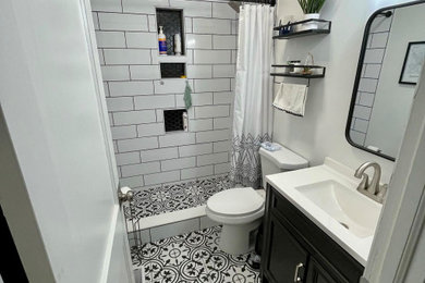 Example of a minimalist white tile and ceramic tile ceramic tile, black floor and single-sink bathroom design in Other with black cabinets, white walls, white countertops, a niche and a freestanding vanity