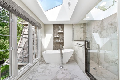 Trendy gray tile and white tile freestanding bathtub photo in Chicago with a hinged shower door