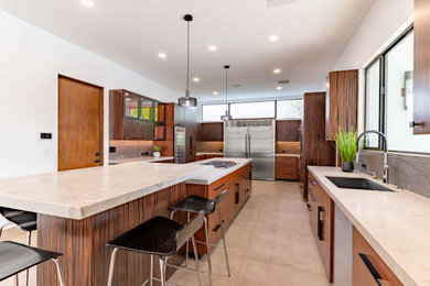 Trendy u-shaped beige floor kitchen photo in Phoenix with flat-panel cabinets, medium tone wood cabinets, gray backsplash, stainless steel appliances, an island and beige countertops