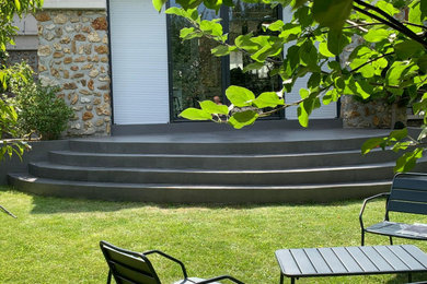 Cette image montre une terrasse arrière minimaliste de taille moyenne avec une dalle de béton et aucune couverture.
