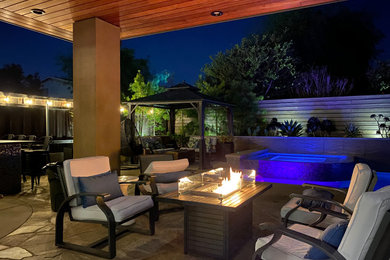 Pool landscaping - large contemporary backyard stone and rectangular infinity pool landscaping idea in San Diego