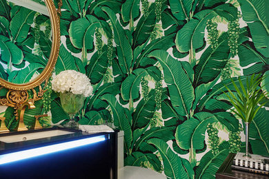 マイアミにあるトロピカルスタイルのおしゃれなトイレ・洗面所 (家具調キャビネット、黒いキャビネット、緑の壁、アンダーカウンター洗面器、マルチカラーの床、黒い洗面カウンター) の写真