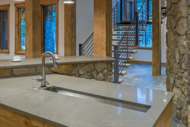 Eat-in kitchen - huge modern l-shaped ceramic tile eat-in kitchen idea in Denver with a drop-in sink, flat-panel cabinets, light wood cabinets, granite countertops, gray backsplash, stone slab backsplash, stainless steel appliances and an island