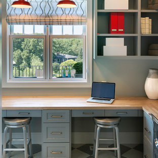 Klassisk inredning av ett mellanstort hemmabibliotek, med grå väggar, linoleumgolv och ett inbyggt skrivbord