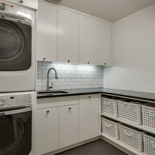 Imagen de cuarto de lavado en L, escandinavo, de tamaño medio, con fregadero bajoencimera, armarios con paneles lisos, puertas de armario blancas, paredes blancas, lavadora y secadora apiladas, encimera de cuarzo compacto y suelo de baldosas de cerámica