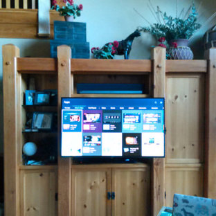 This is an example of a medium sized contemporary open plan home cinema in Manchester with blue walls, light hardwood flooring and a wall mounted tv.