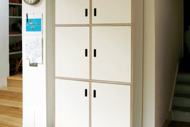 Inspiration for a medium sized modern single-wall kitchen/diner in London with an integrated sink, flat-panel cabinets, white cabinets, wood worktops, green splashback, metro tiled splashback, stainless steel appliances, medium hardwood flooring, no island and green worktops.