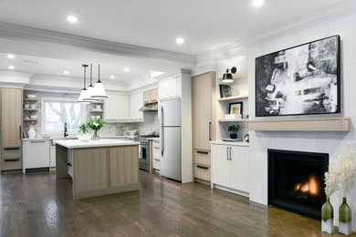 Inspiration for a large contemporary l-shaped open plan kitchen in Toronto with a belfast sink, shaker cabinets, light wood cabinets, engineered stone countertops, white splashback, porcelain splashback, stainless steel appliances, dark hardwood flooring, an island, brown floors and white worktops.