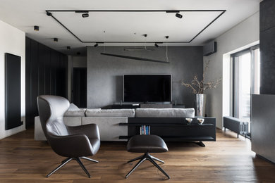 This is an example of a modern loft-style family room in Rome with dark hardwood floors, a standard fireplace and a freestanding tv.
