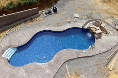 Large 1960s side yard concrete and custom-shaped natural water slide photo in Other