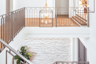 Example of a large transitional wooden u-shaped metal railing staircase design in Charlotte with wooden risers