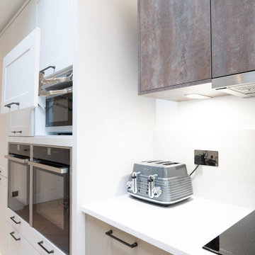a simple freestanding microwave is hidden behind a door