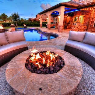 Immagine di un grande patio o portico classico dietro casa con un focolare, graniglia di granito e un tetto a sbalzo