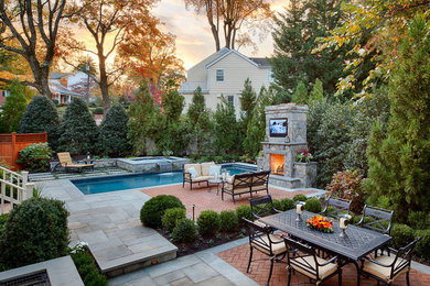 Traditional backyard patio in DC Metro with brick pavers and with fireplace.