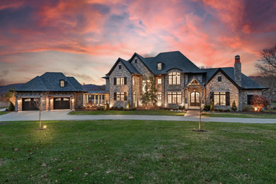 Example of a huge minimalist beige three-story stone exterior home design in Nashville with a shingle roof and a black roof