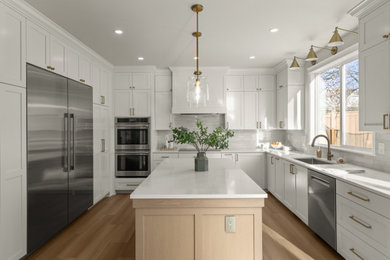 Mid-sized transitional u-shaped brown floor eat-in kitchen photo in Seattle with an undermount sink, shaker cabinets, white cabinets, quartz countertops, beige backsplash, porcelain backsplash, stainless steel appliances, an island and white countertops