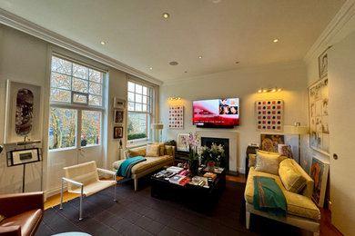 This is an example of a medium sized bohemian living room feature wall in London with a wall mounted tv.