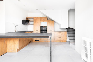 Foto de cocina minimalista grande con puertas de armario de madera en tonos medios, electrodomésticos negros, suelo de baldosas de cerámica, suelo gris, encimeras grises y bandeja