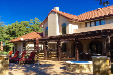 Inspiration for a large mediterranean backyard concrete patio kitchen remodel in Dallas with a pergola