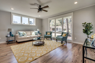 Mid-sized farmhouse open concept light wood floor family room photo in Raleigh with gray walls and a tv stand